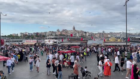 People-explore-Eminonu-Pier-Kadikoy-during-Hari-Raya-Haji-and-against-the-background-of-Beyoglu-on-the-European-side-of-Istanbul,-between-the-Galata-and-Karakoy-districts,-Turkey