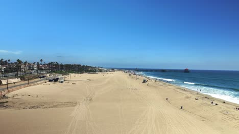 Luftaufnahme,-Die-Den-Strand-Hinunter-Und-In-Richtung-Des-Piers-In-Huntington-Beach,-Kalifornien,-Fliegt