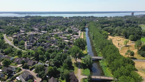 Aerial-drone-shot-above-the-sity-of-Almere-Haven-with-a-Gooilake-on-background,-province-Flevoland,-Netherlands