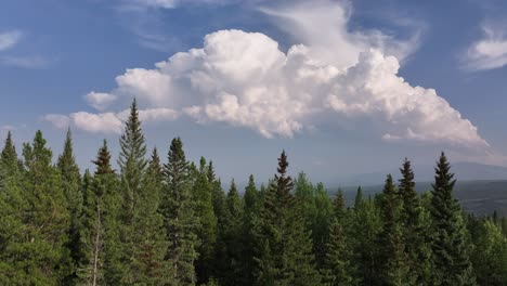 Rising-drone-video-reveals-a-distant-thunder-storm-over-the-foothills-of-Alberta,-Canada