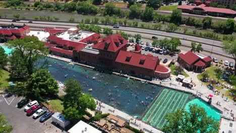 Drohnenaufnahme-Von-Menschen,-Die-In-Einem-Pool-Im-Glenwood-Hot-Springs-Resort-Im-Sonnigen-Colorado,-USA,-Schwimmen