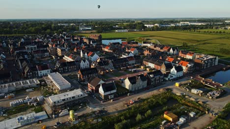 Luftaufnahme-Einer-Neu-Erbauten-Stadt-Mit-Einem-Heißluftballon-In-Der-Ferne