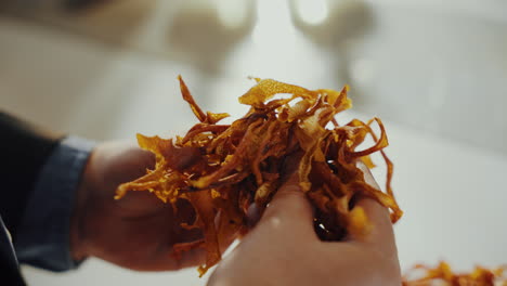 Close-up-shot-of-a-man's-hands-holding-yellow-aromatic-dried-spice-herbs-while-checking-it