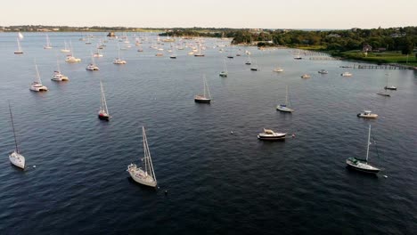 Aerial-view-of-many-sailboats-in-the-bay-during-golden-hour