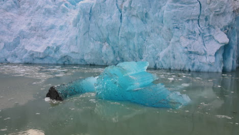 Waterfall-on-a-floating-melting-iceberg-at-the-Dawes-Glacier,-Endicott-Arm-Fjord,-Alaska