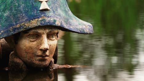 Derelict-statue-of-Napoleon-in-river-water,-close-up-view