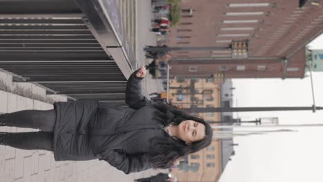 Vertical-Shot-Of-Stylish-Lady-Walking-Along-The-Street-Of-Stockholm-With-Riddarholmen-Church-Exterior-Revealed