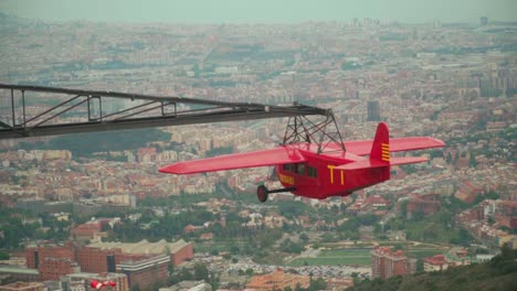 Atemberaubendes-Video-Eines-Roten-Segelflugzeugs,-Das-Sich-Langsam-In-Der-Luft-Dreht-Und-Einen-Panoramablick-Auf-Barcelona-Bietet