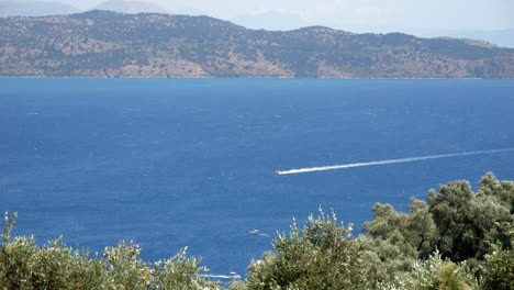 Motorbootfahrt-Auf-Dem-Blauen-Wasser-Des-Ionischen-Meeres-In-Der-Nähe-Der-Insel-Korfu,-Mit-Hohen-Bergen-Im-Hintergrund