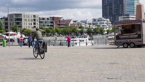 Active-senior-male-on-bike-riding-with-travel-bags-in-the-city-center-of-Antwerp,-Belgium