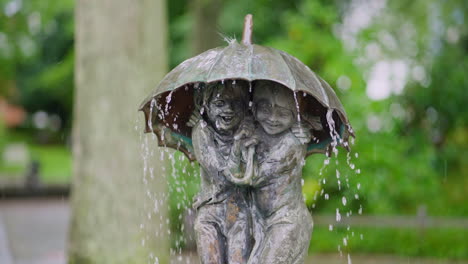 Brunnen-Mit-Einer-Skulptur-Von-Zwei-Kindern-Unter-Einem-Regenschirm-Des-Bildhauers-Frido-Graziani,-Stadt---Binz,-Deutschland