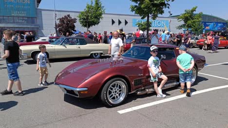 Chevrolet-Corvette-C3-Stingray-at-historic-vintage-car-festival-in-E-Motion-Park,-Avion-Shopping-Park,-Ostrava-with-children-around