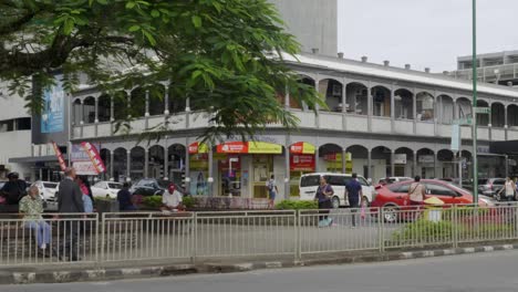 Traffic-in-the-city-centre-of-Suva,-Fiji-with-historic,-colonial-era-buildings-in-the-background