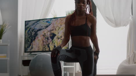 Fitness-woman-with-dark-skin-practicing-yoga-workout-in-living-room
