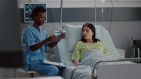 Nahaufnahme-Einer-Afroamerikanischen-Krankenschwester,-Die-Die-Röntgenaufnahme-Der-Knochen-Erklärt
