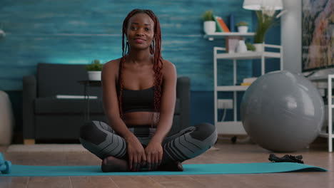 Portrait-of-black-athlete-sitting-in-lotus-position-on-floor-enjoying-morning-workout
