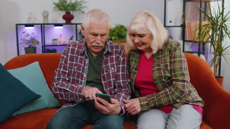 Amazed-senior-grandparents-use-mobile-smartphone-receive-good-news-message-shocked-by-sudden-victory