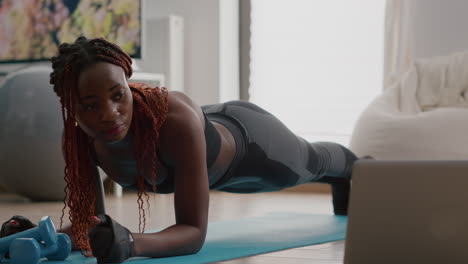 Afroamerikanische-Frau-Mit-Sportbekleidung,-Die-Yoga-Übungen-Auf-Der-Fitnesskarte-Ausdehnt