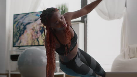 Afro-american-fit-woman-wearing-sportswear-doing-leg-exercises