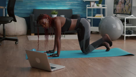 Athletic-sport-black-woman-doing-morning-fitness-routine-watching-fitness-workout-video