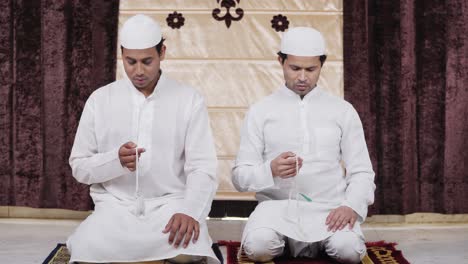 Muslim-men-praying-to-Allah-God-using-praying-beads