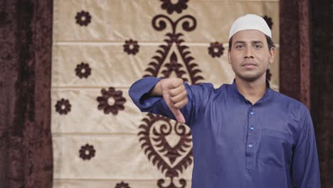 Hombre-Musulmán-Mostrando-Los-Pulgares-Hacia-Abajo-Con-Copyspace