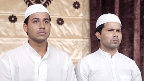 Two-muslim-men-seriously-looking-at-something