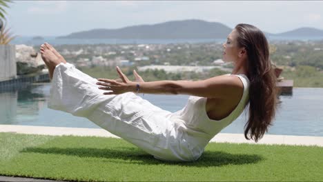 Turista-Tranquilo-Practicando-Yoga-En-El-Equilibrio-De-Asanas-Junto-A-La-Piscina-Contra-La-Ciudad-En-La-Costa