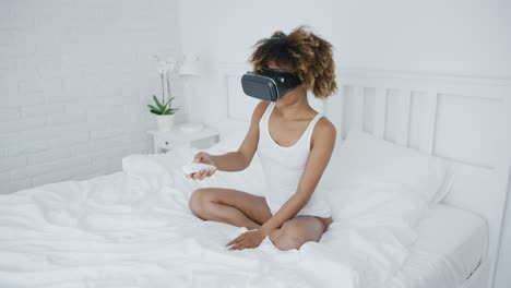 Content-woman-in-VR-glasses-on-bed