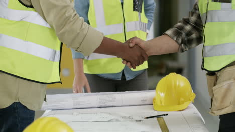 a-group-of-unrecognisable-builders-shaking-hands