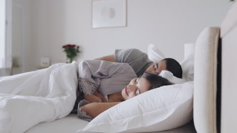 Young-content-cosy-couple-taking-a-nap-in-a-bed