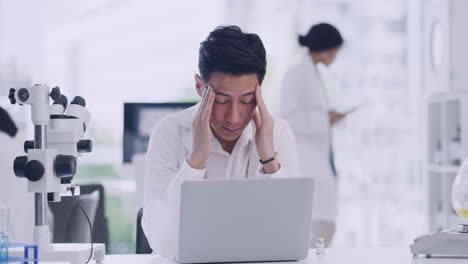 Stressed-male-scientist-working-on-laptop