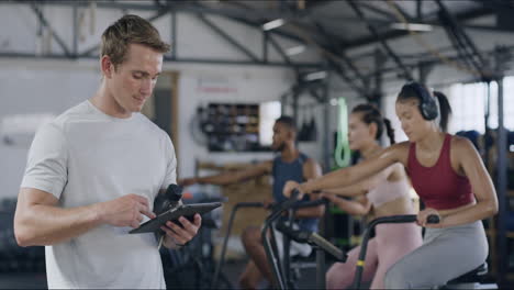 Gym-trainer-using-digital-tablet-to-monitor