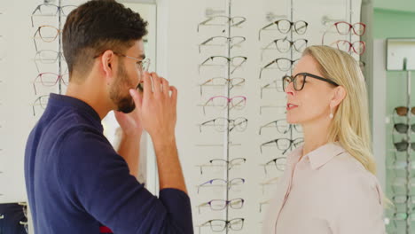 Optician-helping-a-client-choose-glasses