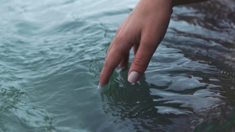 Manicure-hand-of-woman-touch-water-in-sea