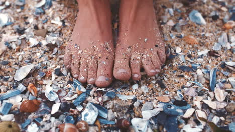 Woman-feet-in-sand-with-sea-shell-on-the-beach