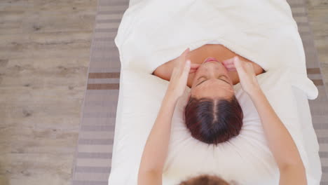 Above-beautiful-woman-lying-on-a-massage-bed