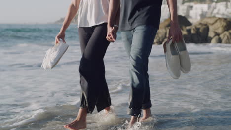 Smiling-young-couple-walking-through-water