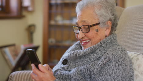 Smartphone,-funny-and-elderly-woman-on-sofa
