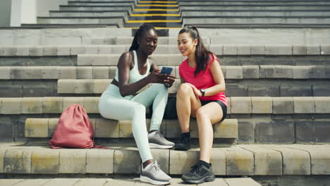 Two-female-athletes-using-a-phone