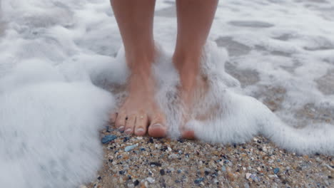 Beach,-woman-feet-and-standing-in-water