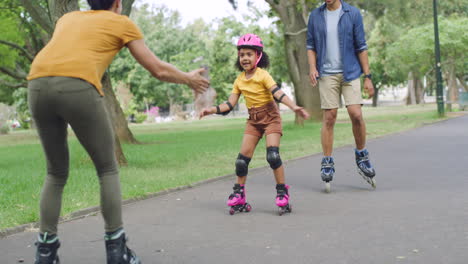 Adorable-girl-learning-to-rollerskate-with-parents
