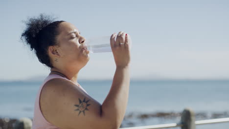 Plus-size-woman-drinking-water-from-bottle
