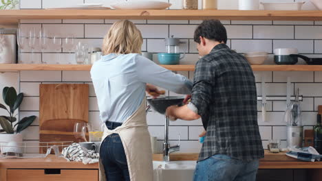 Couple-in-kitchen-cleaning-dishes-together