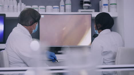 Two-scientists-looking-at-cells-on-a-computer