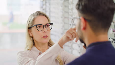 Woman-checking-sight-of-man-buying-glasses