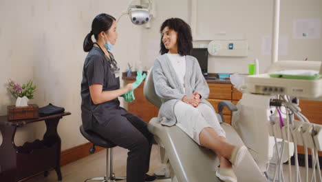 Mujer-Dentista-Consultando-Con-Un-Cliente-Sobre-Oral
