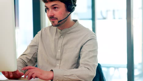 Male-call-center-agent-with-a-headset-working