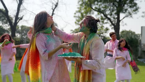 Indian-man-putting-Holi-colors-on-his-wife-face-at-a-festival