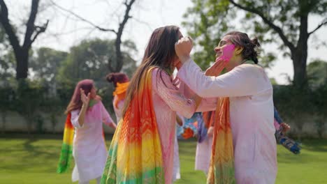 Affectionate couple celebrating Holi, Festival of Colors, woman covring  eyes of man stock photo